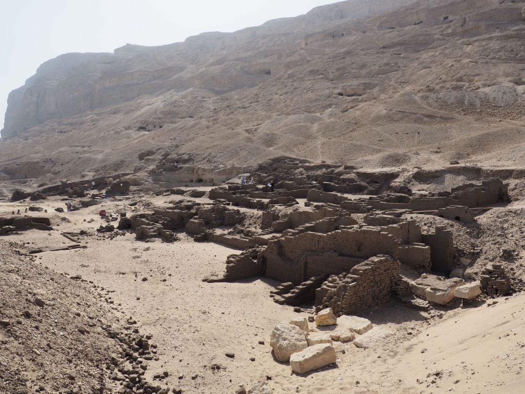 a dusty scene of a hillside and ruins ostraca