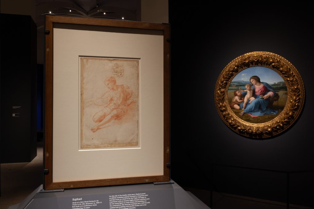 Close-up of a framed Renaissance drawing alongside a circular painting of the Madonna and child in a gilded frame.