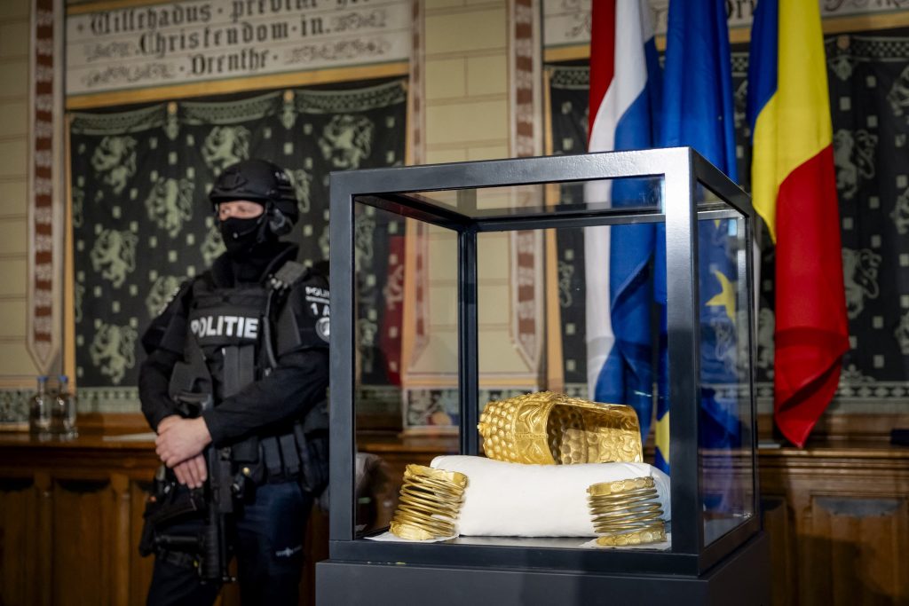 a police man with a mask next to a glass box with gold in it