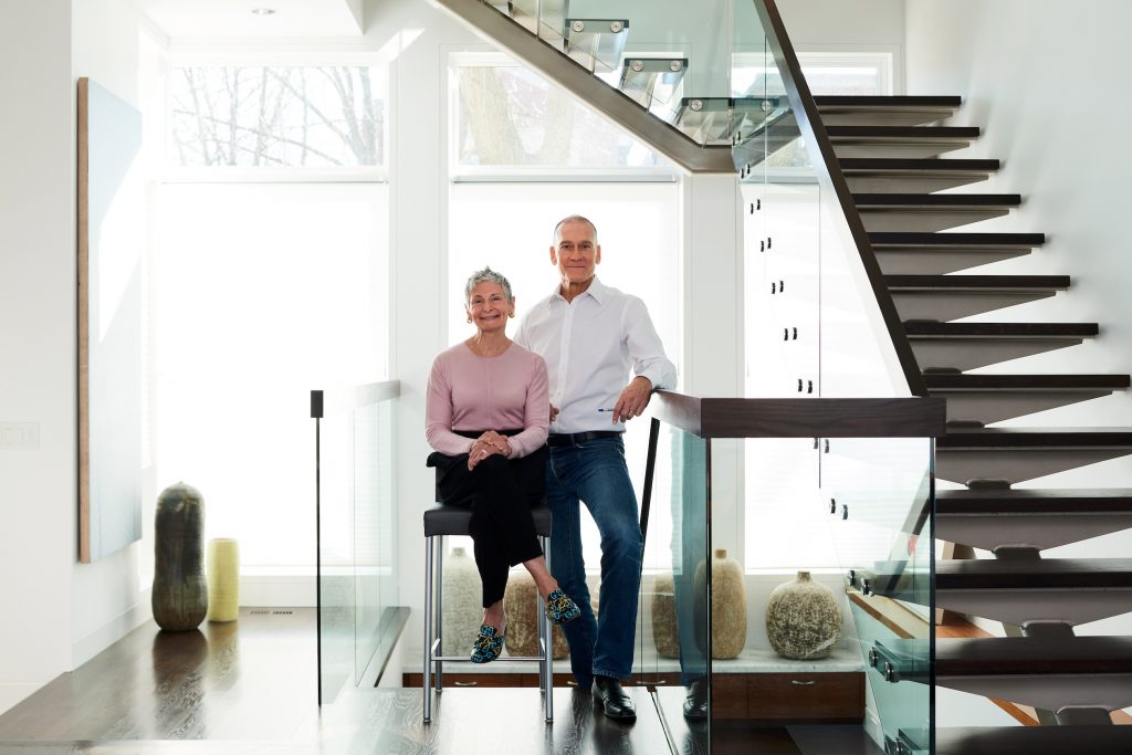A man and a woman pose for the camera in their sunny home
