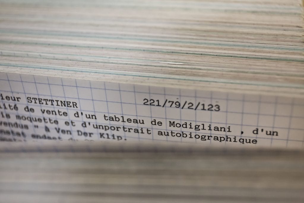 A close up photo of a thick stack of index card records, opened to show the top of one card. 