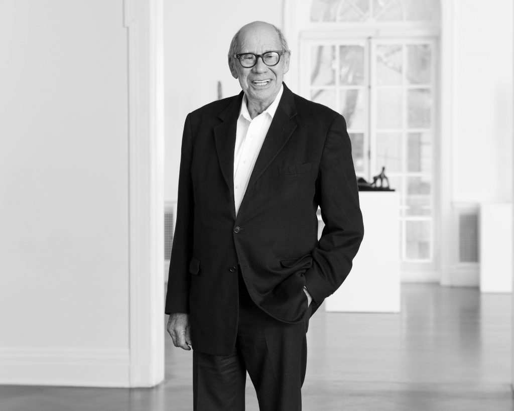 A black and white photo of a besuited gentleman