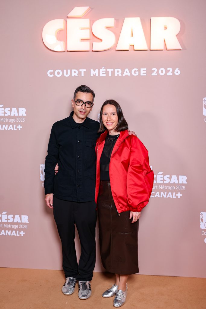 Alexandre Singh and Natalie Musteata pose together on the red carpet in front of a backdrop reading “César – Court Métrage 2026,” smiling with arms around each other.
