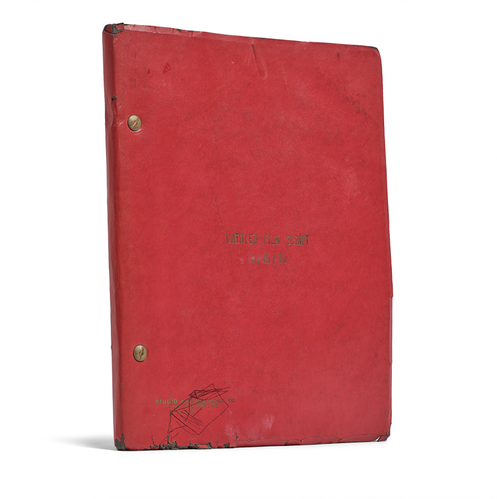A photograph of a red notebook with "UNTITLED FILM SCRIPT" embossed into it with gold, and "4/15/76" embosed below it, as seen on an all white background