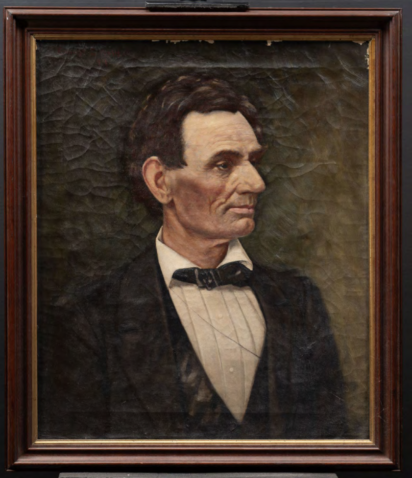A photograph of a portrait of Abraham Lincoln in a suit, looking off to the right, against a dark brown background